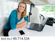 woman inside campervan smiling using laptop. Стоковое фото, агентство Ingram Publishing / Фотобанк Лори