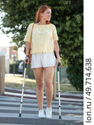 young woman on crutches is crossing the road. Стоковое фото, агентство Ingram Publishing / Фотобанк Лори