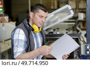 worker lining up a stack of paper in cutting machine. Стоковое фото, агентство Ingram Publishing / Фотобанк Лори
