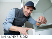 handyman installing fitted cabinet drawer. Стоковое фото, агентство Ingram Publishing / Фотобанк Лори