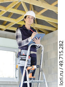 female worker inspecting wooden timbers in a property. Стоковое фото, агентство Ingram Publishing / Фотобанк Лори