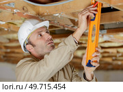 builder in uniform holding a level. Стоковое фото, агентство Ingram Publishing / Фотобанк Лори