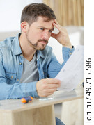 frustrated young man reading a manual a. Стоковое фото, агентство Ingram Publishing / Фотобанк Лори