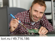happy repairman working in technical support fixing computer laptop tr. Стоковое фото, агентство Ingram Publishing / Фотобанк Лори