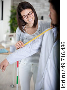 young female fashion designer taking measurements of a man. Стоковое фото, агентство Ingram Publishing / Фотобанк Лори