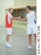 Men shaking hands on sports court. Стоковое фото, агентство Ingram Publishing / Фотобанк Лори