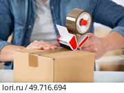 man applying adhesive tape on a packing box. Стоковое фото, агентство Ingram Publishing / Фотобанк Лори