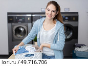 attractive woman toils washing and folding clothes at the laundromat. Стоковое фото, агентство Ingram Publishing / Фотобанк Лори