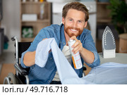 capable disabled man ironing a shirt. Стоковое фото, агентство Ingram Publishing / Фотобанк Лори