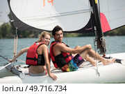 young couple steering a catamaran. Стоковое фото, агентство Ingram Publishing / Фотобанк Лори