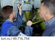 turner operates on a mechanical lathe with apprentice. Стоковое фото, агентство Ingram Publishing / Фотобанк Лори