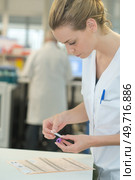 Laboratory worker sticking label onto blood sample. Стоковое фото, агентство Ingram Publishing / Фотобанк Лори
