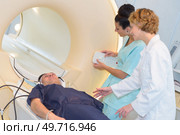 nurses reassuring patient as he enters mri scanner. Стоковое фото, агентство Ingram Publishing / Фотобанк Лори