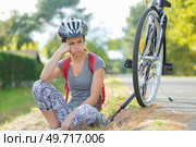 frustrated female cyclist has a puncture. Стоковое фото, агентство Ingram Publishing / Фотобанк Лори