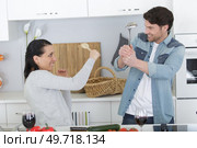 funny couple fighting with utensils tools in kitchen. Стоковое фото, агентство Ingram Publishing / Фотобанк Лори