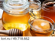 beautiful fresh natural  linden honey in big glass jar with herbal tea  at wooden tray in beautiful sunny light. close up. Стоковое фото, агентство Ingram Publishing / Фотобанк Лори