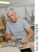 man is using circular sander. Стоковое фото, агентство Ingram Publishing / Фотобанк Лори