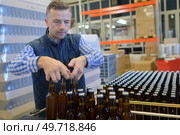 brewer holding beer bottles in crate at brewery. Стоковое фото, агентство Ingram Publishing / Фотобанк Лори