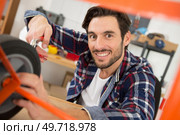 man fixing trolley wheel good quality. Стоковое фото, агентство Ingram Publishing / Фотобанк Лори