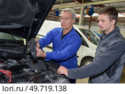 auto mechanic teacher and trainee performing tests at mechanic school. Стоковое фото, агентство Ingram Publishing / Фотобанк Лори