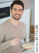 calm adult person standing whisking eggs in the bowl. Стоковое фото, агентство Ingram Publishing / Фотобанк Лори
