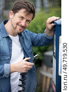 man at repair service station checking tyre pressure with gauge. Стоковое фото, агентство Ingram Publishing / Фотобанк Лори