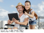 couple on quayside holding a tablet man in a wheelchair. Стоковое фото, агентство Ingram Publishing / Фотобанк Лори