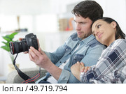 couple at home reviewing photos on camera screen. Стоковое фото, агентство Ingram Publishing / Фотобанк Лори