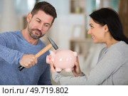 couple holding hammer and piggy bank. Стоковое фото, агентство Ingram Publishing / Фотобанк Лори