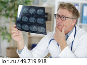 portrait senior doctor over radiography. Стоковое фото, агентство Ingram Publishing / Фотобанк Лори