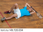 disappointed young man laying on floor after tennis game. Стоковое фото, агентство Ingram Publishing / Фотобанк Лори