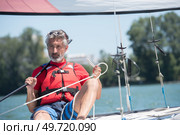 man on sailboat navigating the sails. Стоковое фото, агентство Ingram Publishing / Фотобанк Лори