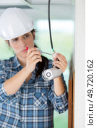 female cctv installer presenting security camera. Стоковое фото, агентство Ingram Publishing / Фотобанк Лори