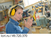 female industrial worker wearing earmuffs. Стоковое фото, агентство Ingram Publishing / Фотобанк Лори