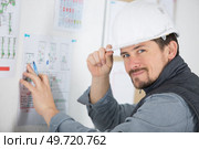 builder tipping hardhat stood by notice board. Стоковое фото, агентство Ingram Publishing / Фотобанк Лори