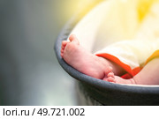Tiny newborn feet peeking out from a cradle, capturing a sweet and peaceful moment of infancy. Стоковое фото, фотограф Татьяна Степанищева / Фотобанк Лори