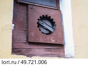 Industrial fan mounted in a window using a DIY chipboard panel with drilled holes, showcasing improvised ventilation. Стоковое фото, фотограф Татьяна Степанищева / Фотобанк Лори