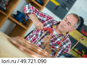 portrait of a workman bending copper pipe. Стоковое фото, агентство Ingram Publishing / Фотобанк Лори