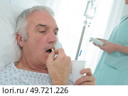 senior man at hospital taking a pill. Стоковое фото, агентство Ingram Publishing / Фотобанк Лори