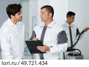 senior builder giving instructions to younger worker. Стоковое фото, агентство Ingram Publishing / Фотобанк Лори