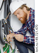 electrician working on wires connection of electrics. Стоковое фото, агентство Ingram Publishing / Фотобанк Лори