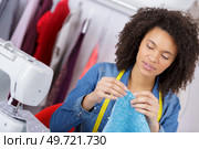 a female dressmaker measuring cloth on cutting table. Стоковое фото, агентство Ingram Publishing / Фотобанк Лори