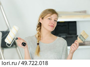 female decorator holding paintbrush and roller. Стоковое фото, агентство Ingram Publishing / Фотобанк Лори