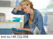 picture of woman wiping her sweat while ironing. Стоковое фото, агентство Ingram Publishing / Фотобанк Лори