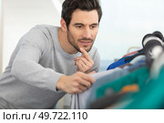 closeup of a young caucasian man choosing clothes. Стоковое фото, агентство Ingram Publishing / Фотобанк Лори
