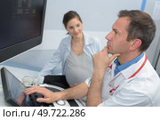 pregnant woman and doctor checking the ultrasound scan. Стоковое фото, агентство Ingram Publishing / Фотобанк Лори