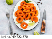 Baked breaded calamari or octopus rings on brown concrete table.. Rings of squid. Стоковое фото, агентство Ingram Publishing / Фотобанк Лори