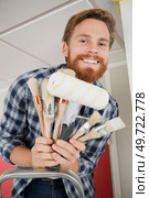 smiling man holding numerous paint brushes. Стоковое фото, агентство Ingram Publishing / Фотобанк Лори