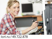 woman fixing printer machine at office. Стоковое фото, агентство Ingram Publishing / Фотобанк Лори