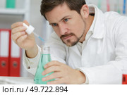 young scientist holding tube with the reagents. Стоковое фото, агентство Ingram Publishing / Фотобанк Лори